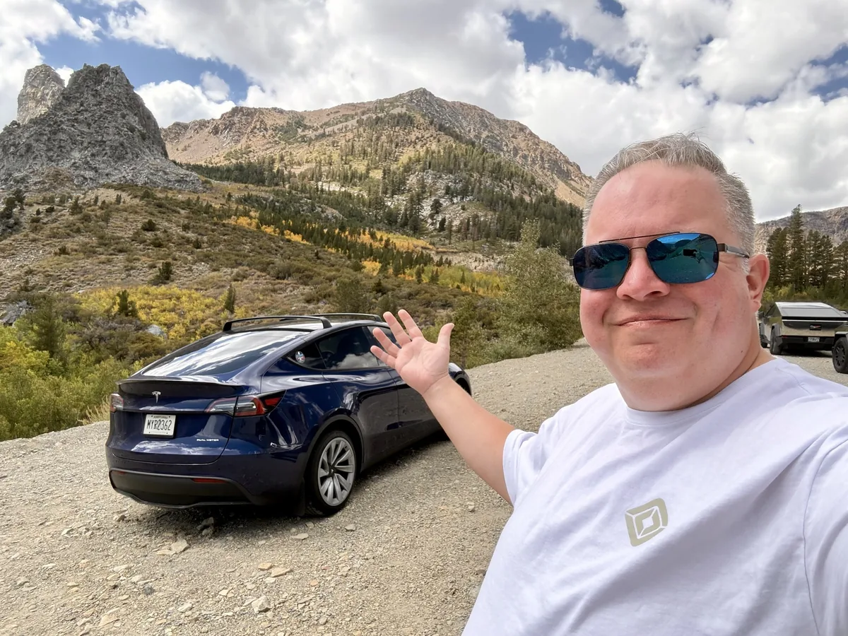 John with his blue Model Y on a mountain road trip